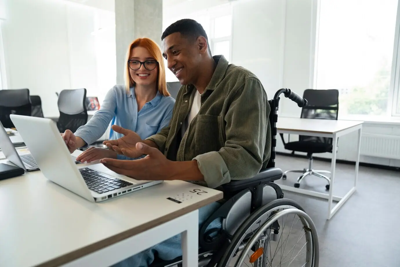 A disabled man in a wheelchair working at his office job